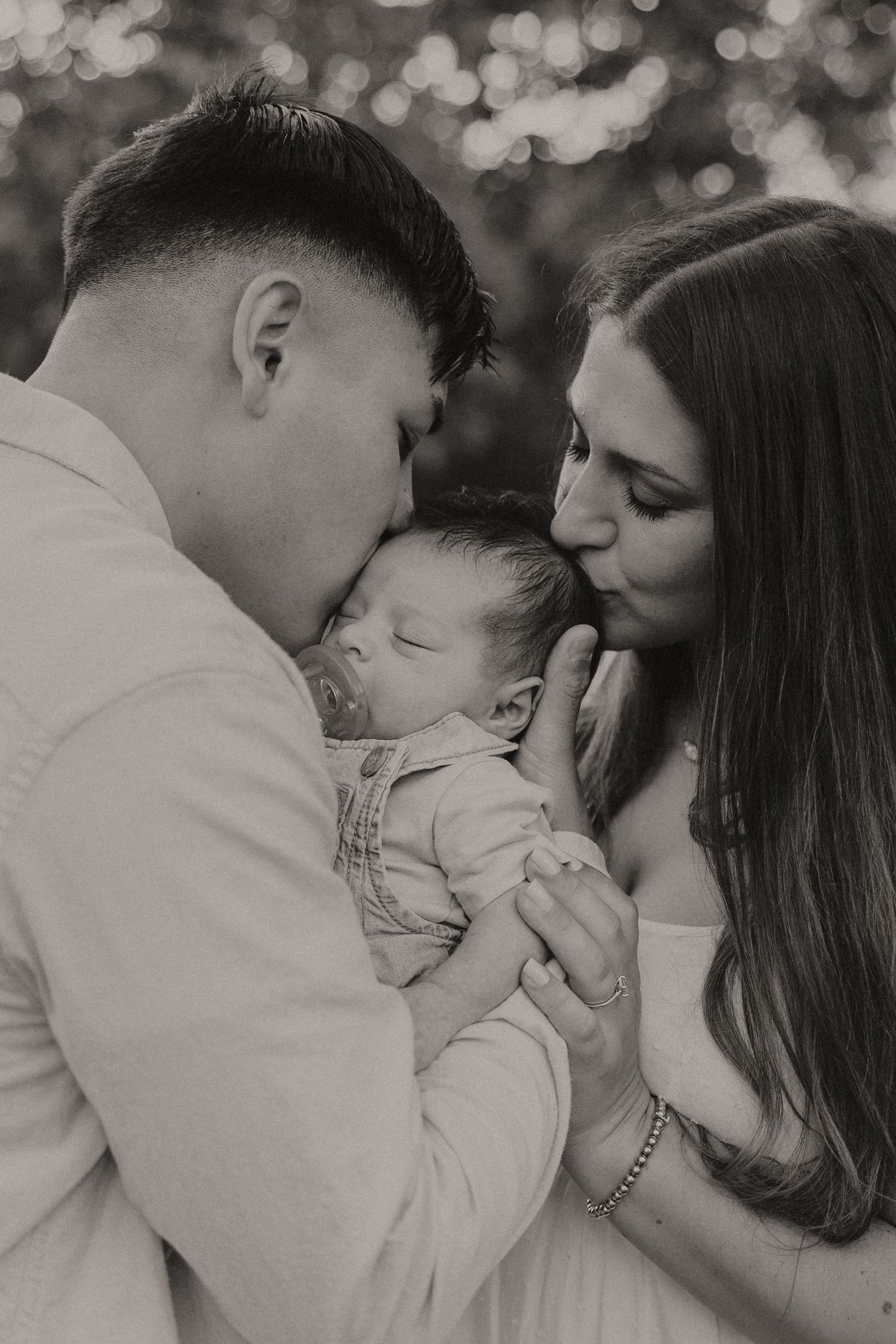 Black and white close-up series of tender family moments with a sleeping infant.