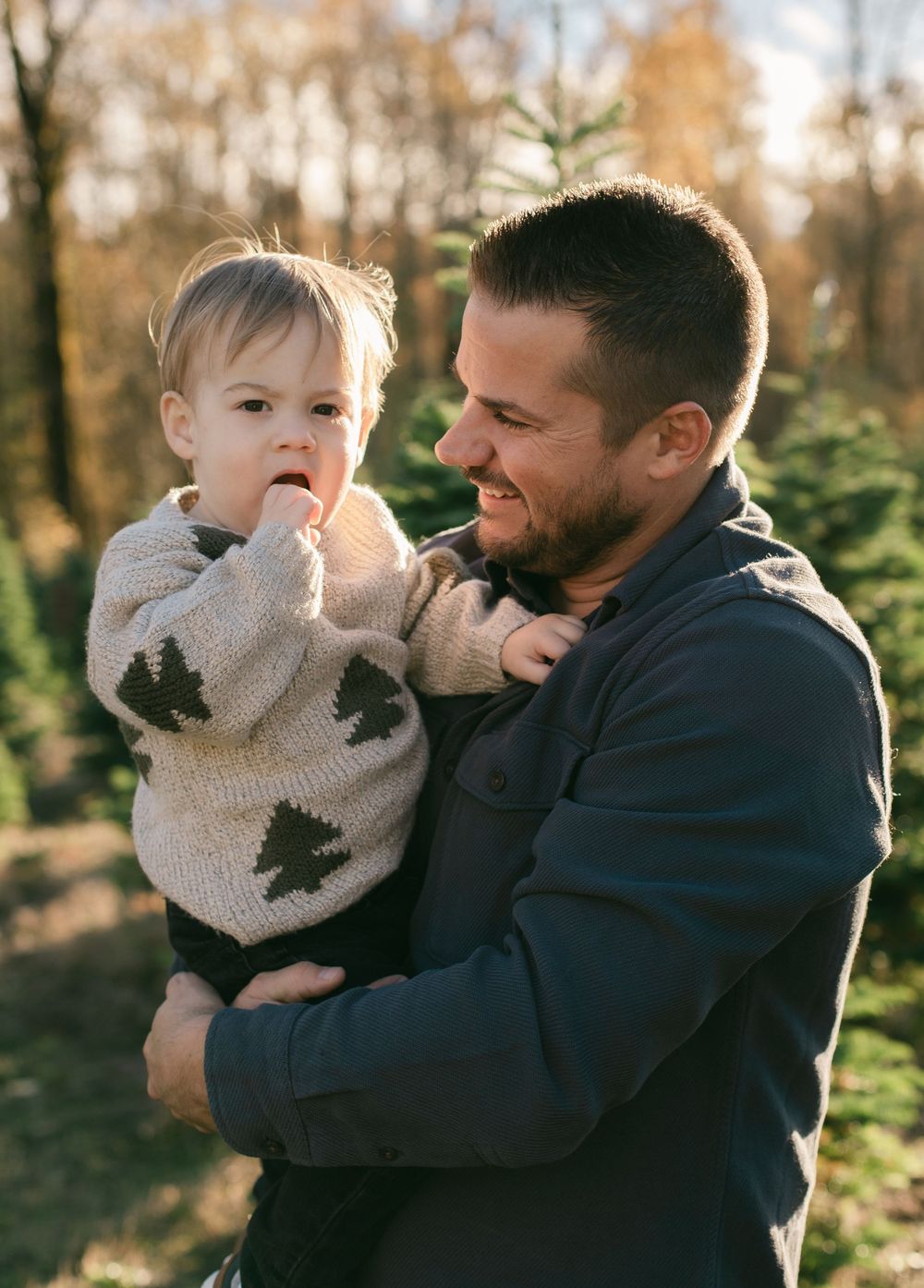 A parent and child share joyful moments together in an outdoor autumn setting during a photo sequence.