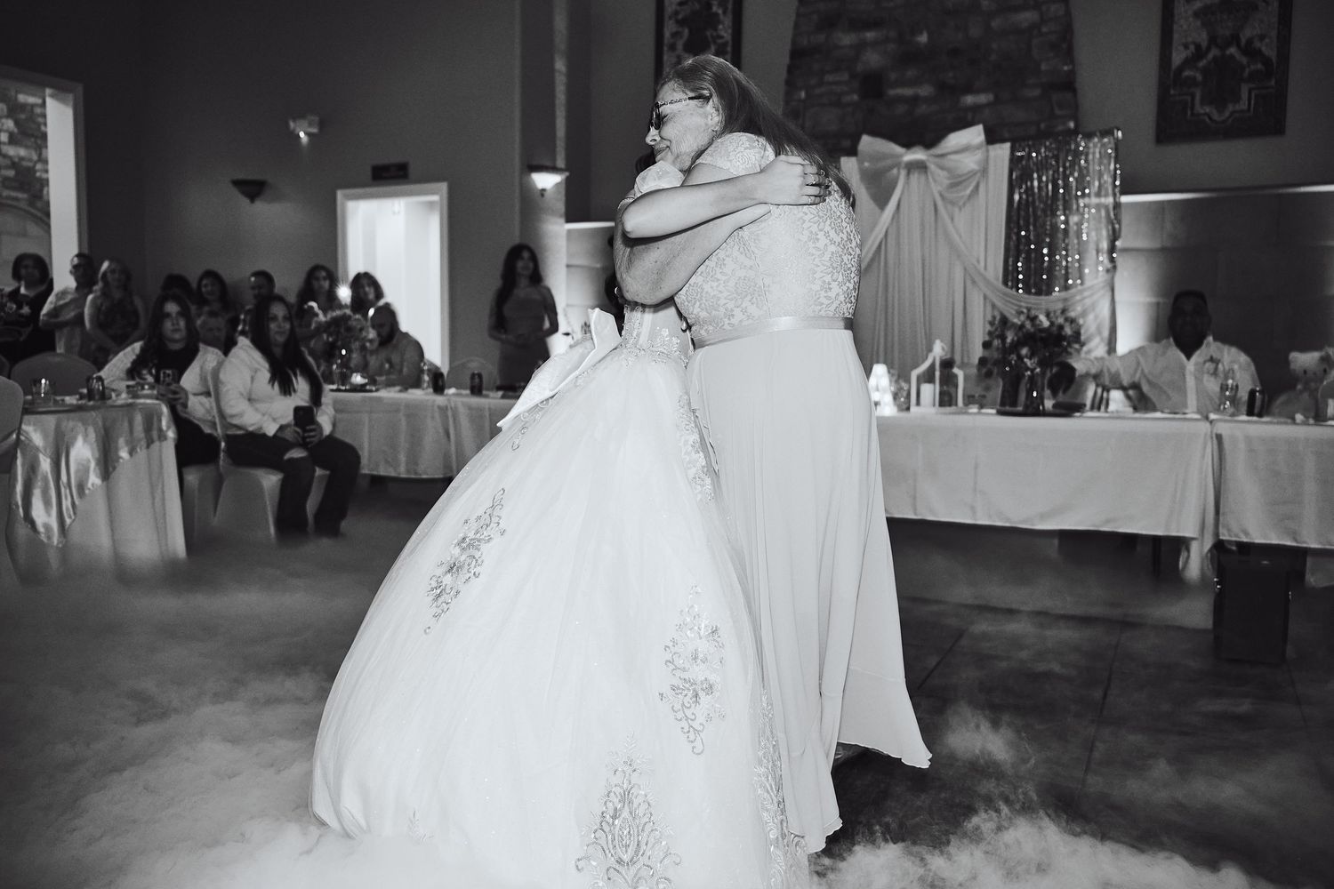 A bride in a white ballgown twirls on the dance floor during a wedding reception.