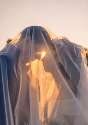 Ethereal wedding veil silhouetted against a sunset sky.