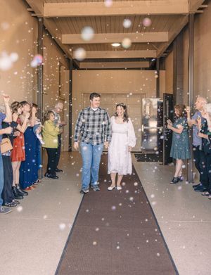 Wedding guests line up in a reception hall creating a celebratory tunnel effect.