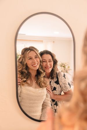 Warm-toned mirror reflection captures a joyful moment in an elegant setting.