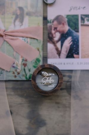 Rustic wooden frames display wedding photographs on a dark surface.