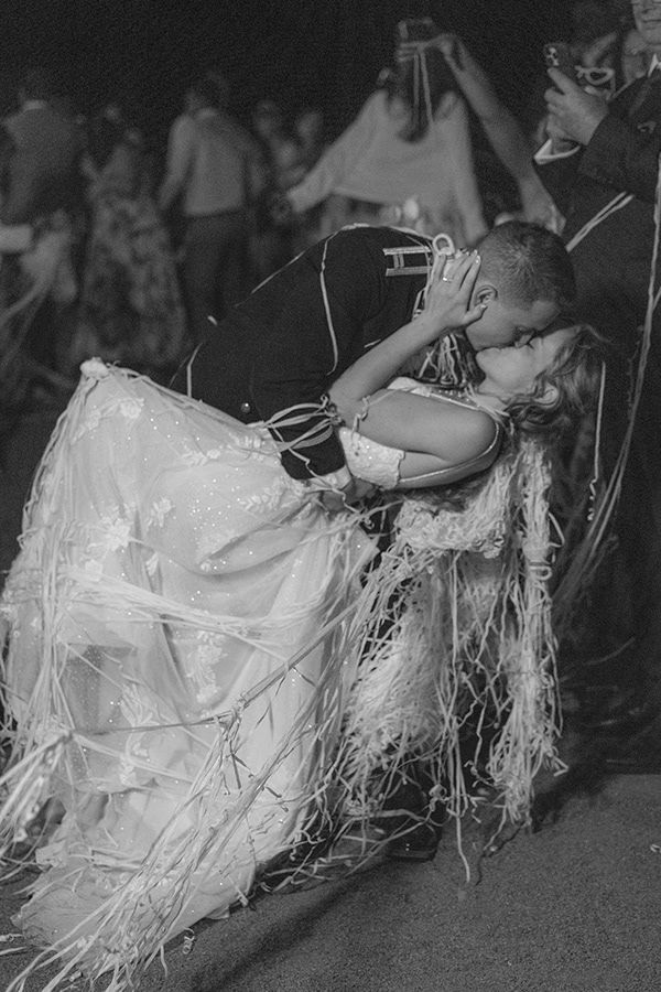 Black and white photo of a wedding dress with flowing details during a dance.