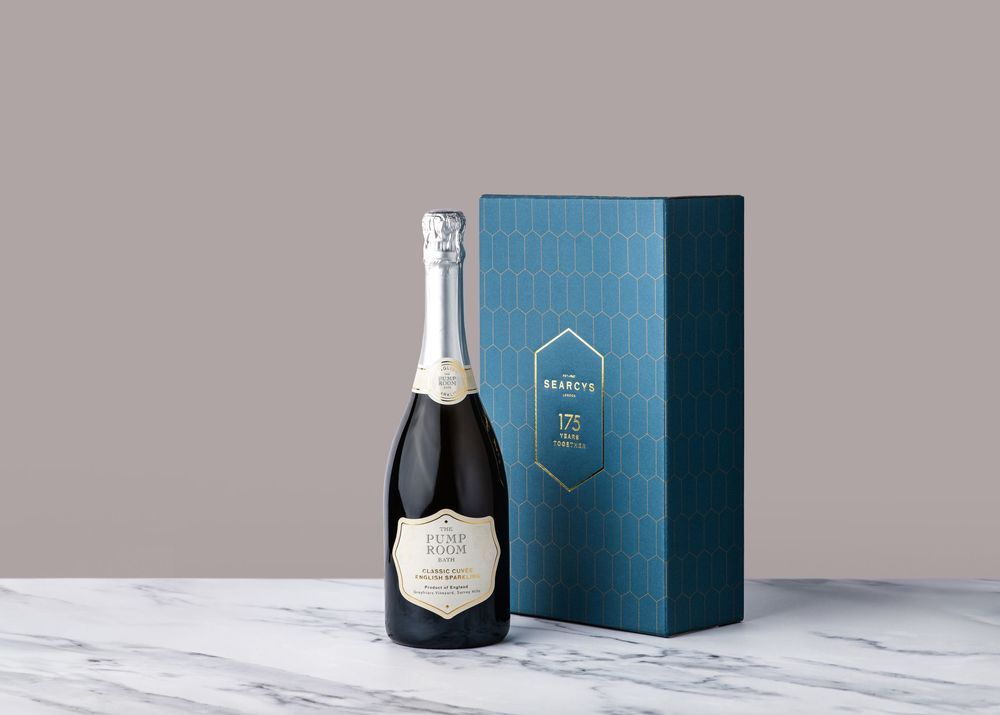 Luxury champagne bottle and blue gift box displayed on white marble surface with elegant presentation.