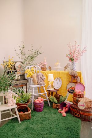 A charming party setup with yellow backdrop, white chairs, and spring floral decorations.