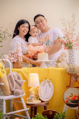 A cheerful birthday celebration setup with yellow decor, cake, and floral arrangements.