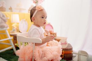 Baby photo session with peach and yellow theme featuring vintage decorations.