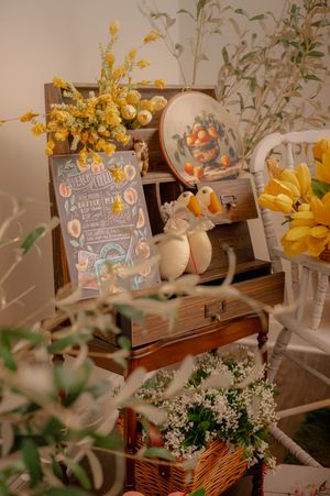 Vintage-style photo setup with yellow flowers, decorative signs, and rustic elements.
