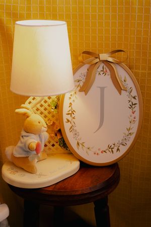 Decorative clock and lamp display on wooden table against yellow wall.