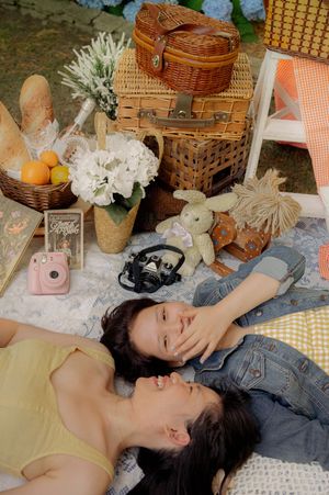 A whimsical picnic scene with vintage decor, flowers, and friends relaxing on a blanket.