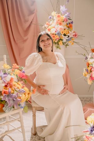 Bright and airy maternity portraits with white dress and floral arrangements.
