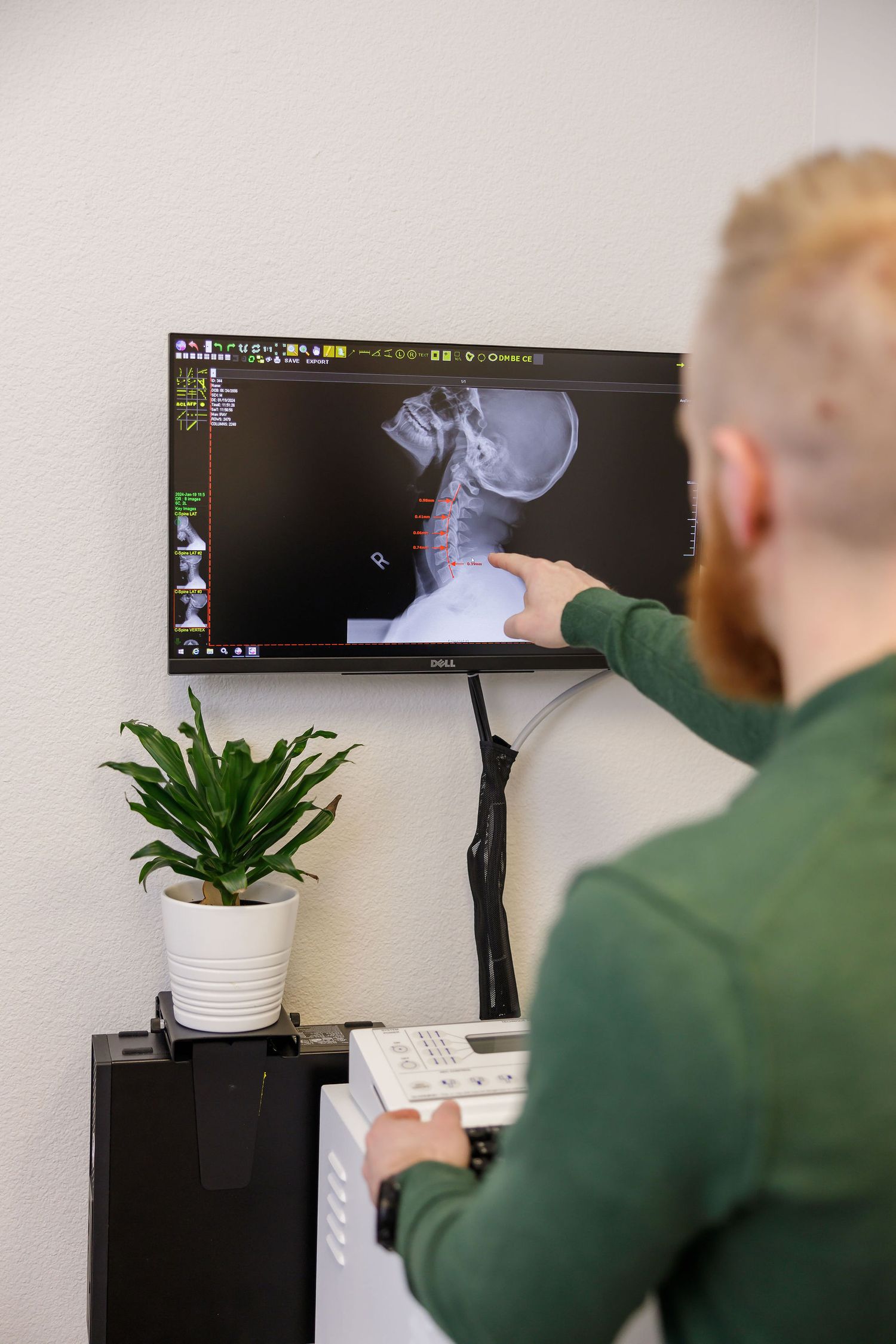 chiropractor branding photo in Sumner, WA wellness health man talking and pointing to cervical vertebrae to educate client about neck curve