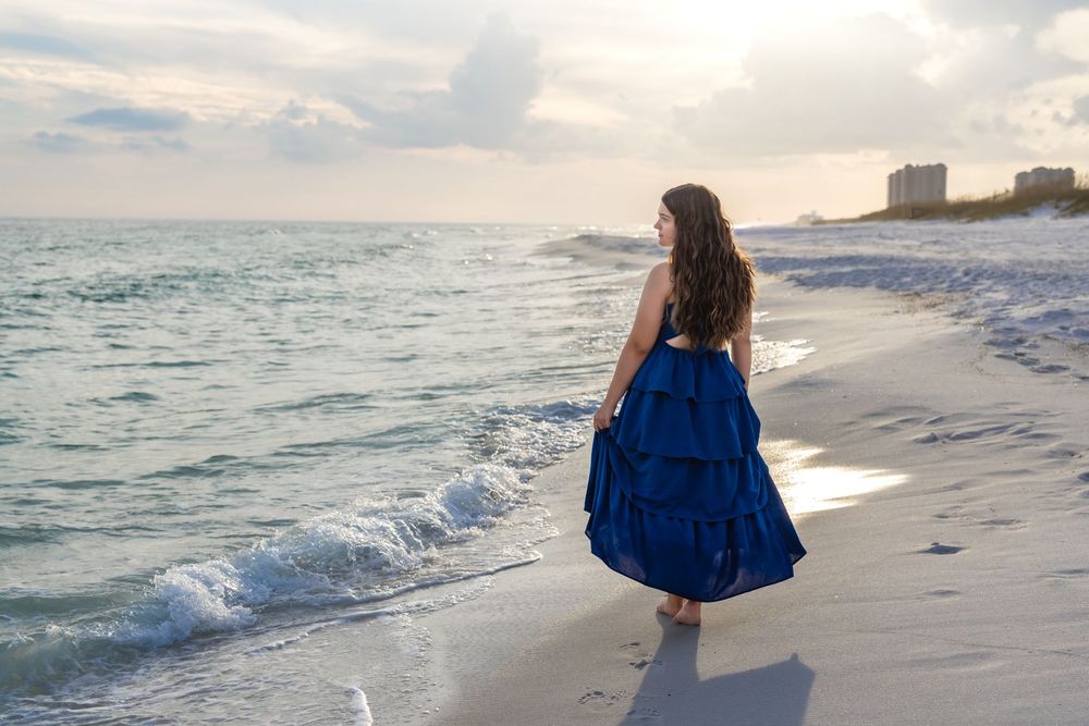 A series of beach photos shows someone in a blue dress walking along the shoreline at sunset.