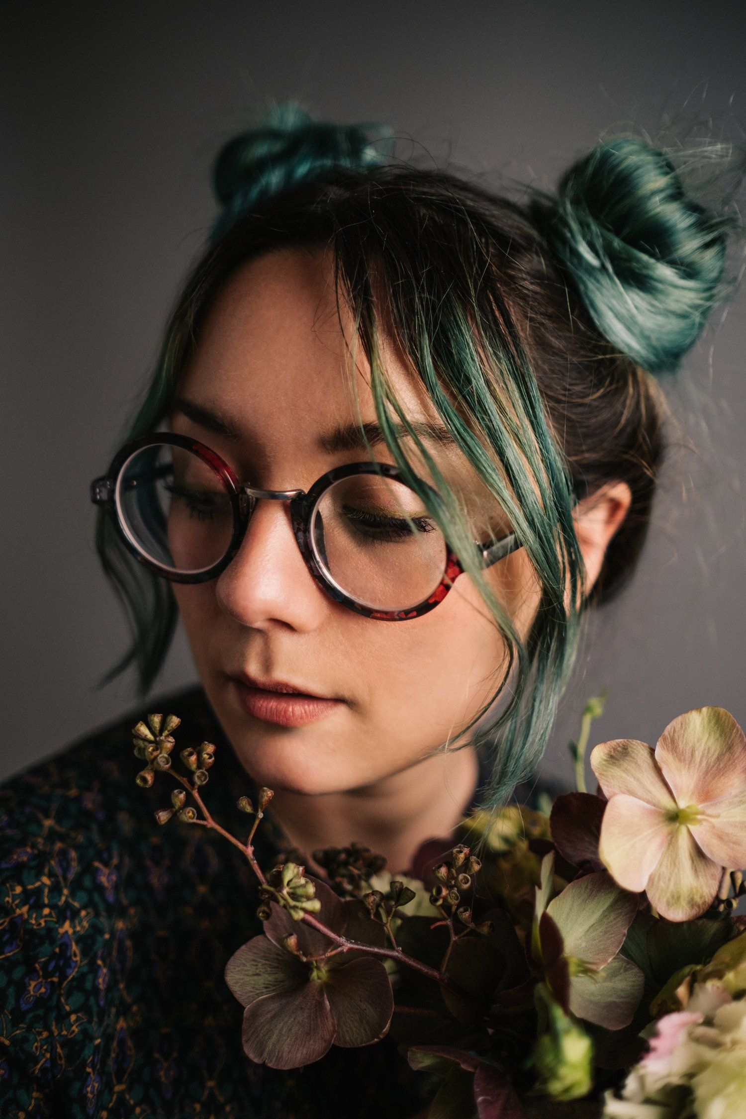 A person in a white sweater poses against a pink background in a series of artistic portrait shots.