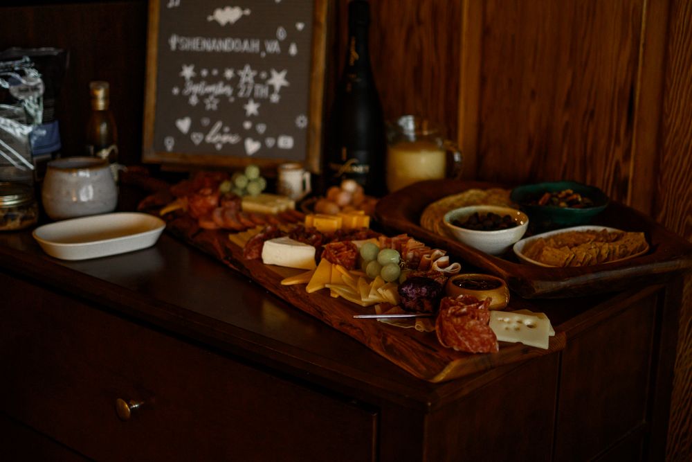 Rustic wedding reception food spread with appetizers on wooden tables.