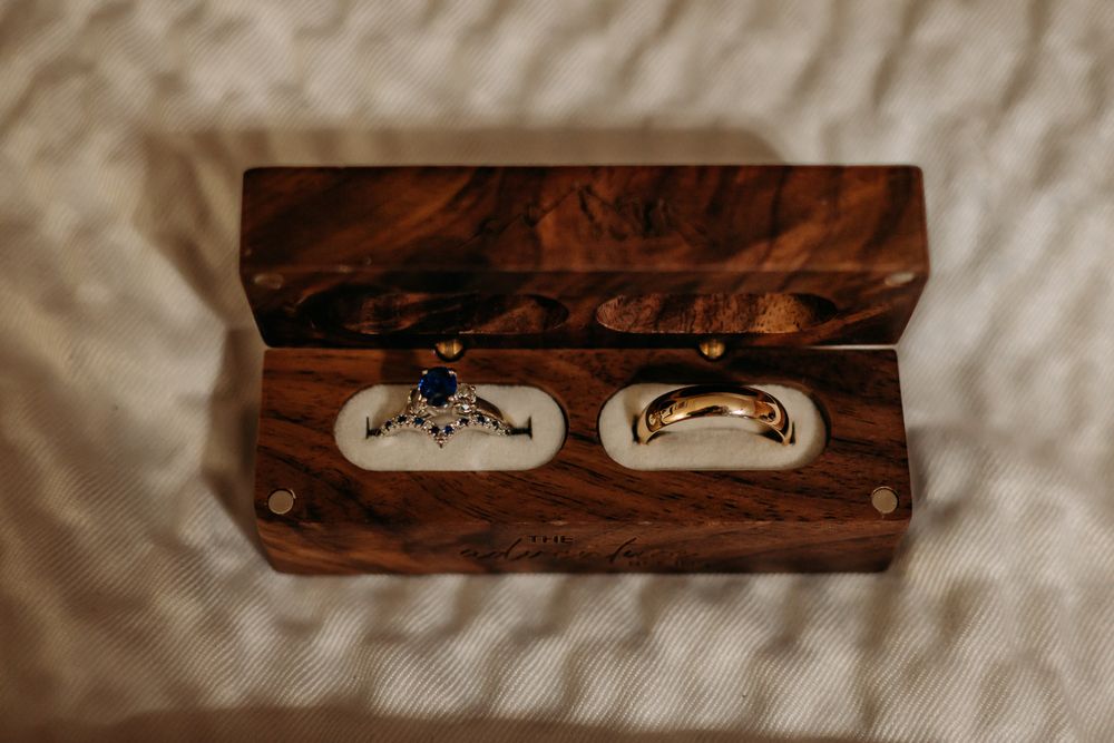 Wooden ring boxes arranged on cream colored textile background.