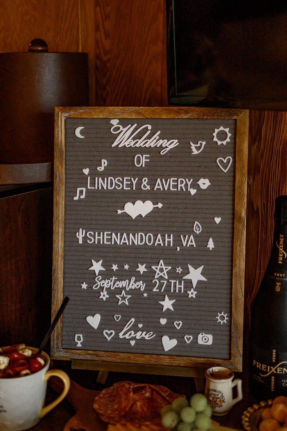 Chalkboard wedding sign with decorative stars and hearts displaying event details.