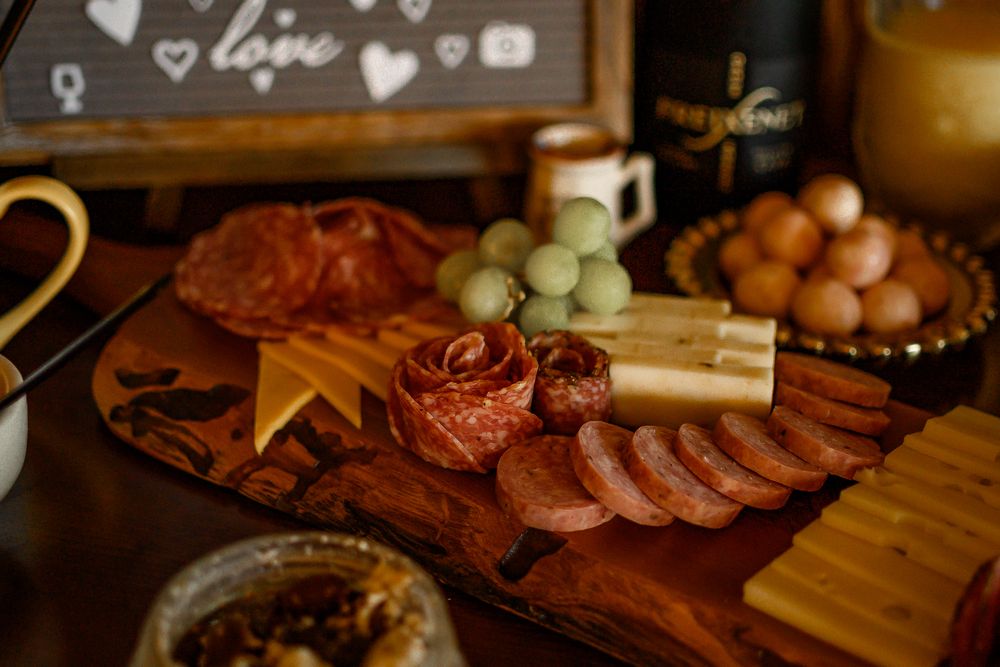 Wedding reception appetizer spread featuring meats, cheeses, and fresh fruits.