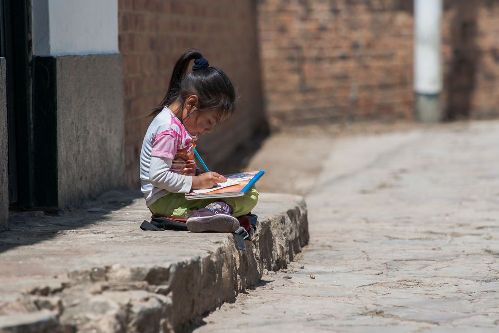 People sitting on steps while reading at a temple in Nepal.