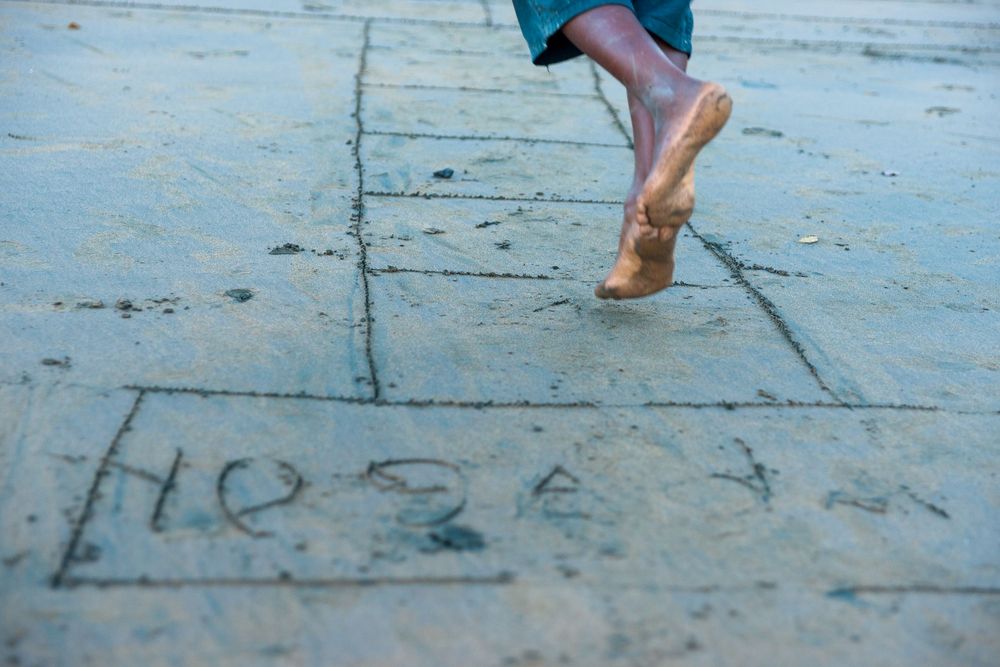 A series of four feet stepping in a pattern against a textured blue surface.