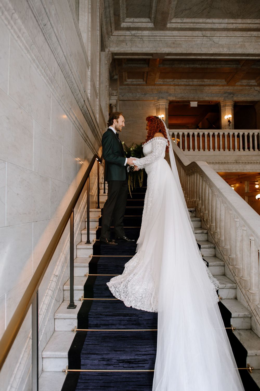 Series of wedding photographs showing couple ascending a grand marble staircase in black suit and flowing white gown.