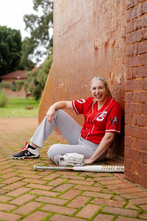Series of outdoor photos showing someone sitting against a brick wall wearing red and gray casual attire.