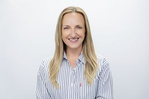 Professional portrait of a person in a striped button-down shirt against a white background.