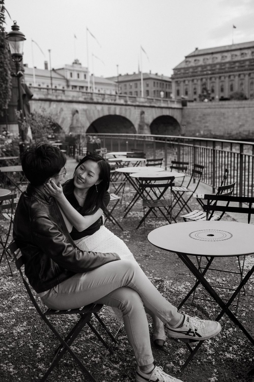 couple sitting in outdoor café looking at each other while being captured by vacation photographer in Stockholm