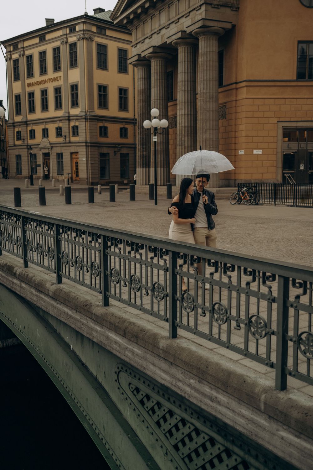 couple taking a walk in rainy Gamla Stan during cinematic vacation photoshoot in Stockholm