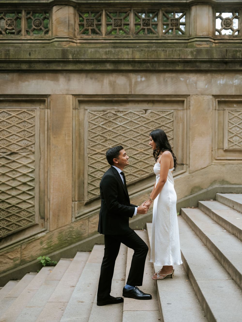 A couple shares a romantic moment on historic stone steps.