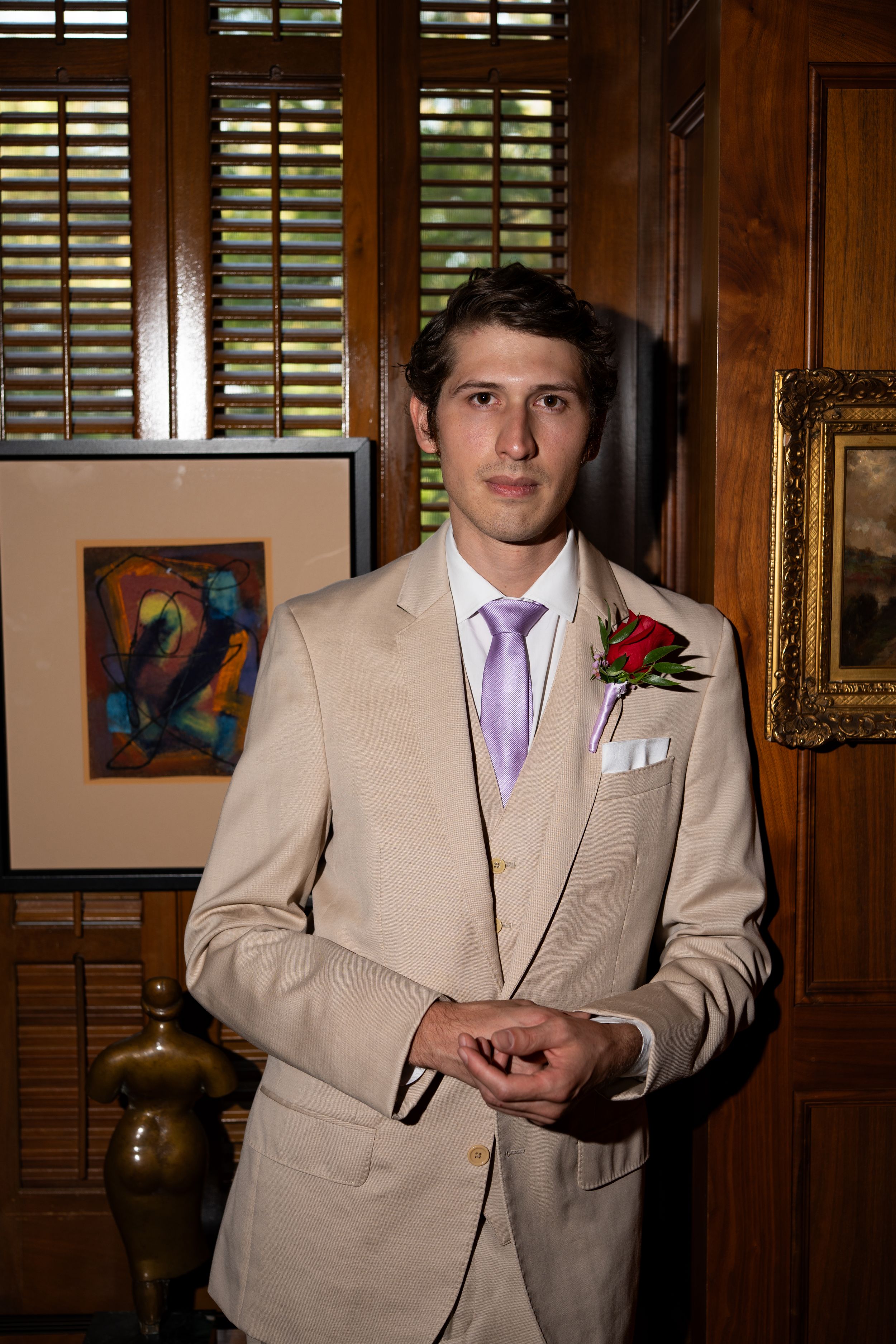 A series of photos showing someone in a light beige suit with purple tie against wooden paneled walls.