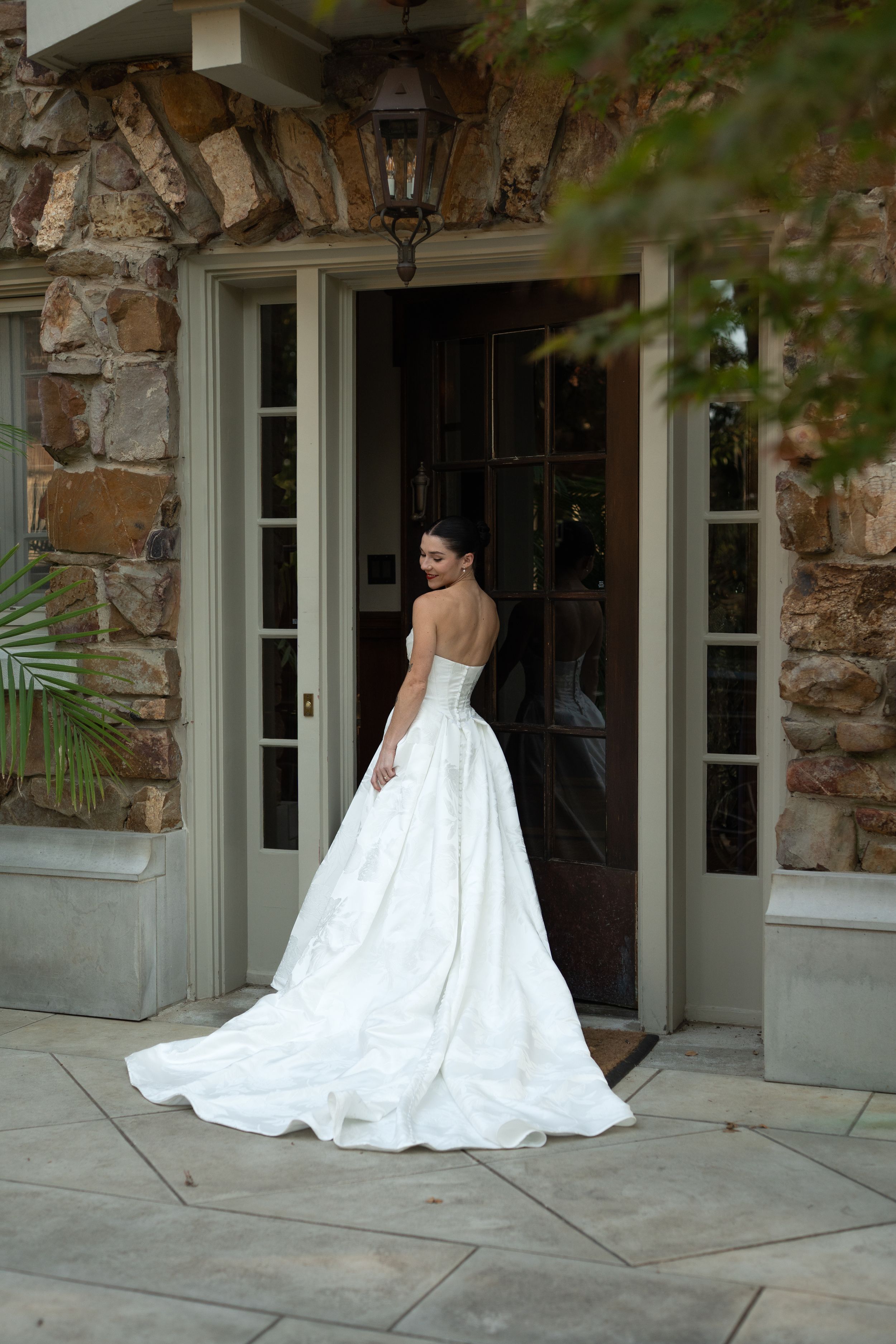 A wedding dress flutters elegantly against a stone wall backdrop in a series of dramatic poses.