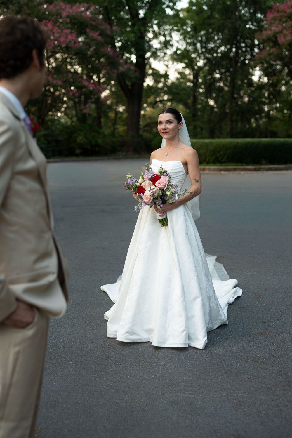 Wedding couple creates artistic portraits on a garden path at sunset.