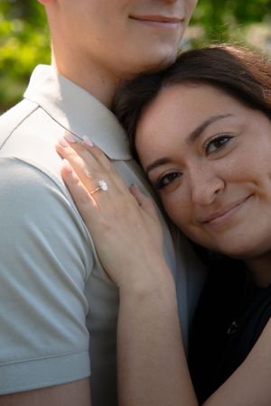 Intimate close-up portrait of engaged couple showing ring.