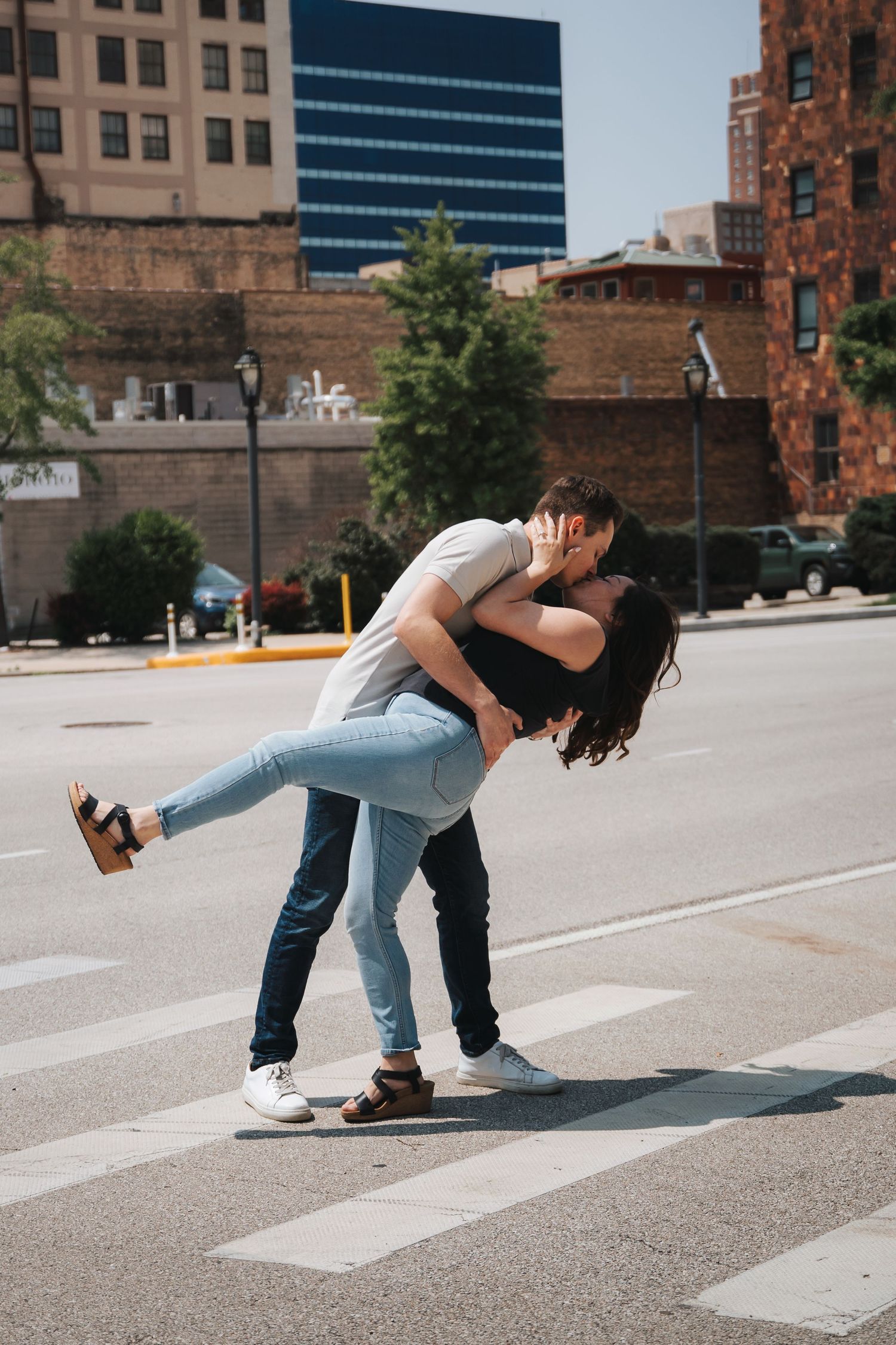 Romantic dip pose on city street during engagement photoshoot.