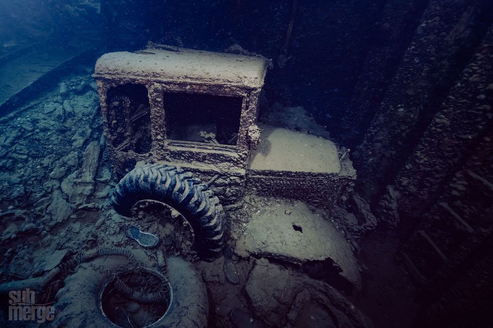 A person explores the abandoned ruins of a snowy building with a dramatic, moody atmosphere.