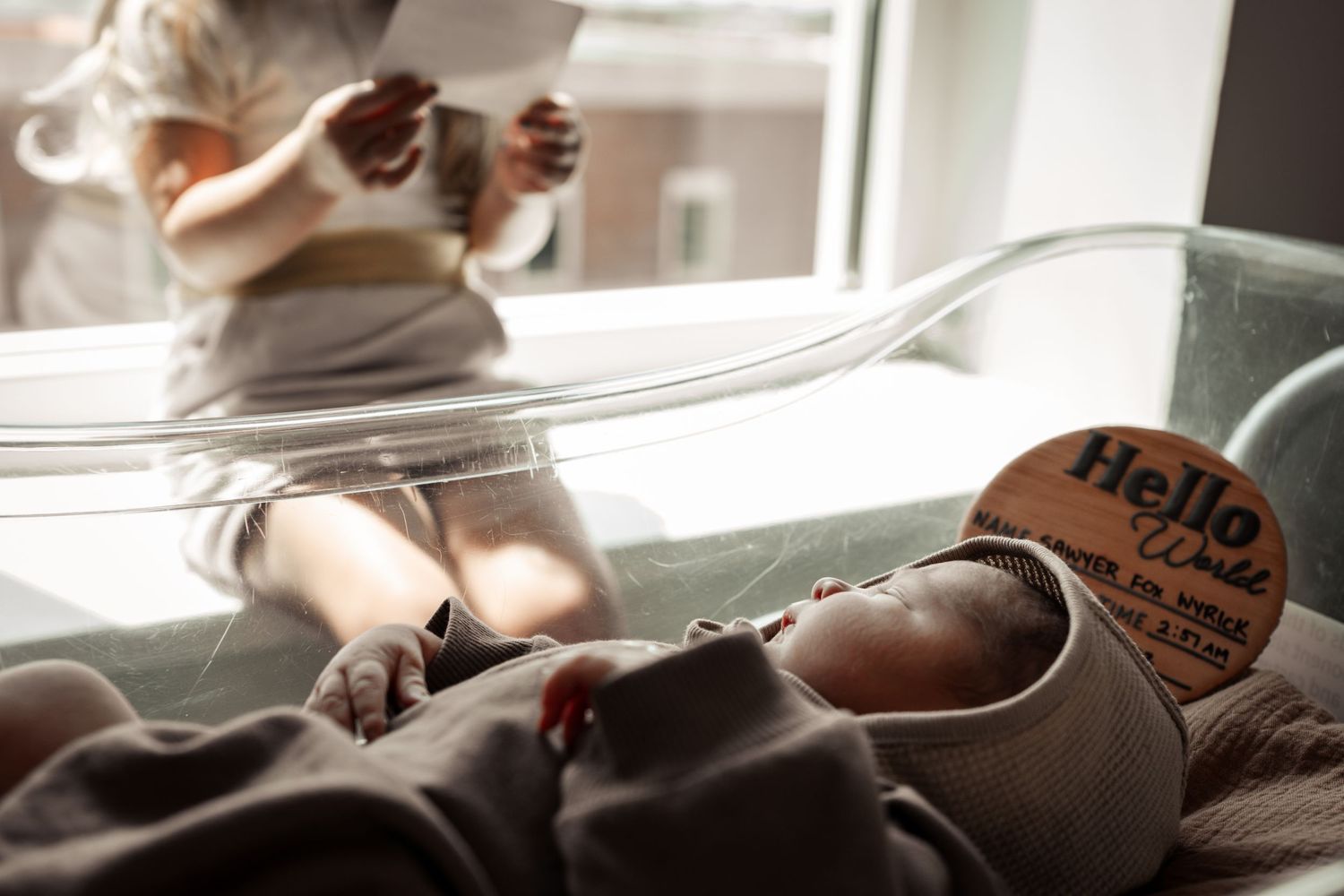 Documentary style image of a toddler girl meeting her baby brother in the hospital during a Fresh 48 session in New Orleans.