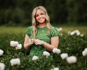 Blonde girl senior wearing green dress at flower farm in New Hampshire.