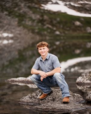 Outdoor senior portraits in the New Hampshire mountains near stream.