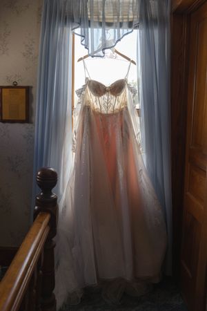 White curtains and butterfly decorations create a dreamy window display in soft natural light.