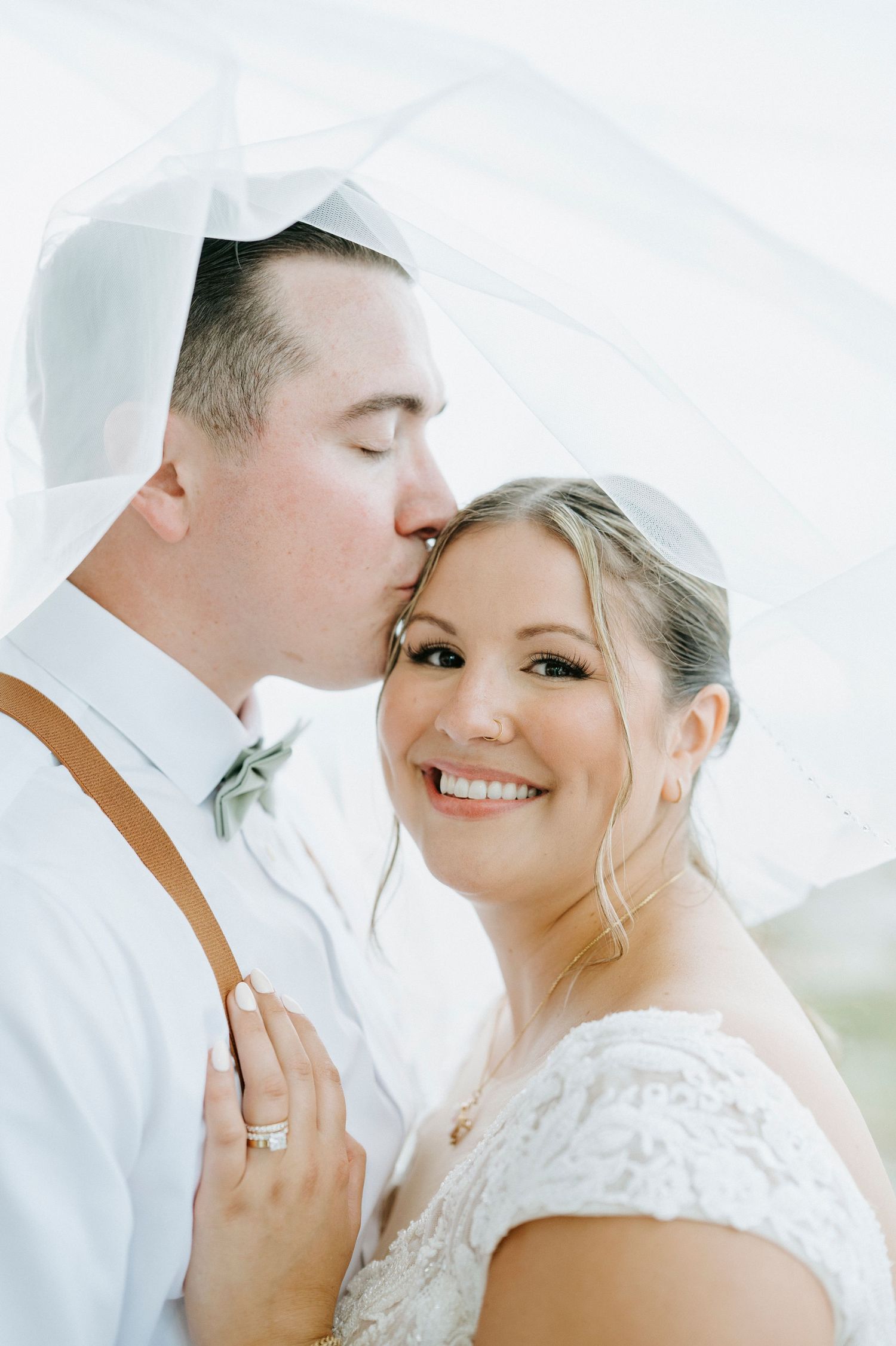 Romantic close-up wedding portraits show tender moments under soft white lighting.