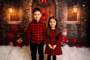 People in red plaid holiday outfits pose against a festive backdrop with Christmas trees and glowing lanterns.