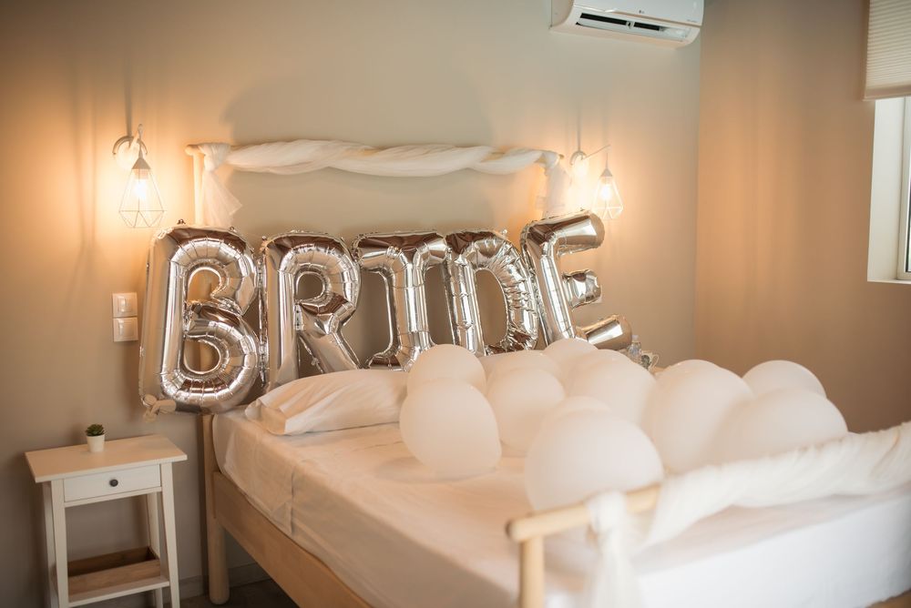 Bridal suite with white decor and balloon letters spelling out 'BRIDE' on the wall.