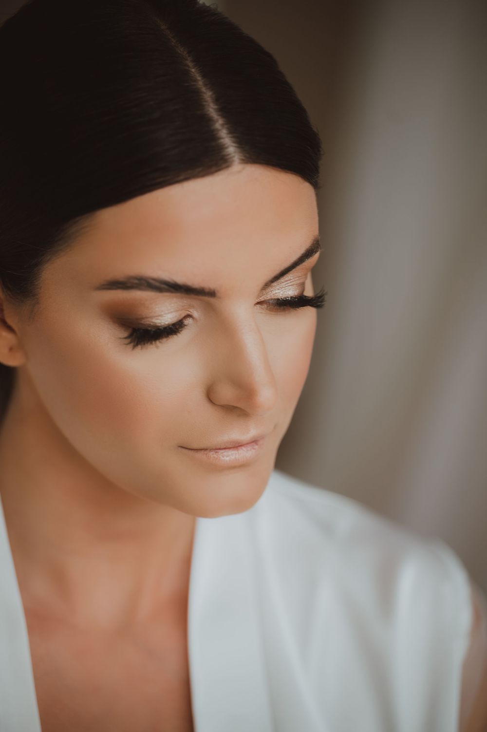 Close-up detail shot showing elegant bridal makeup with long eyelashes and natural tones.