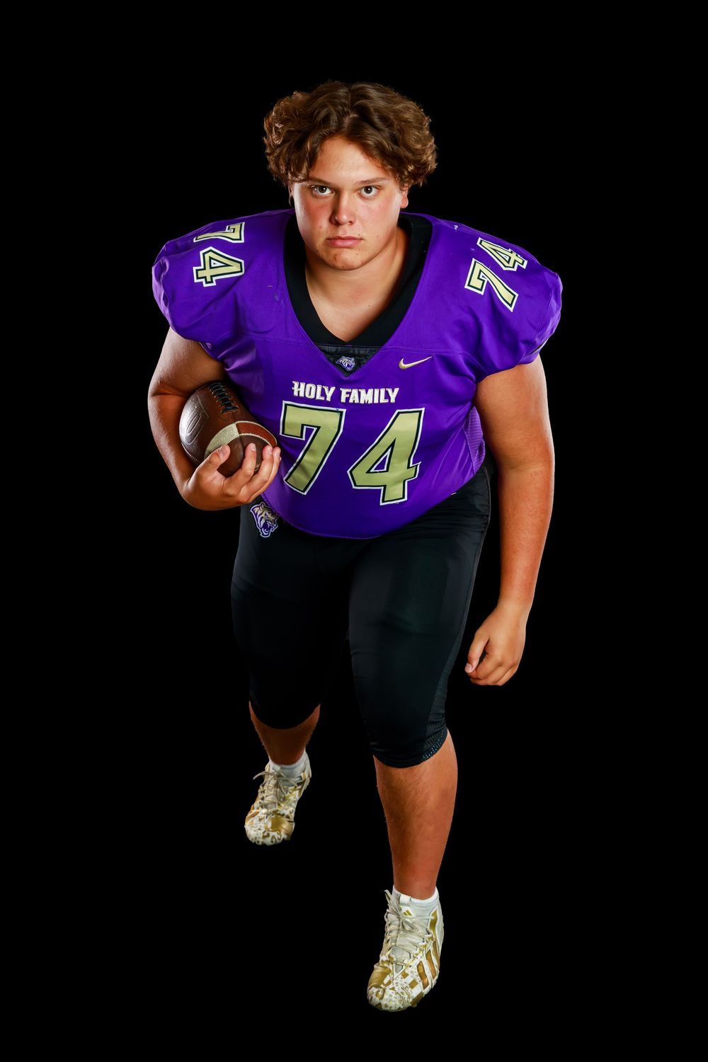 Football player in purple jersey poses in dynamic athletic stances against black background for sports portraits.