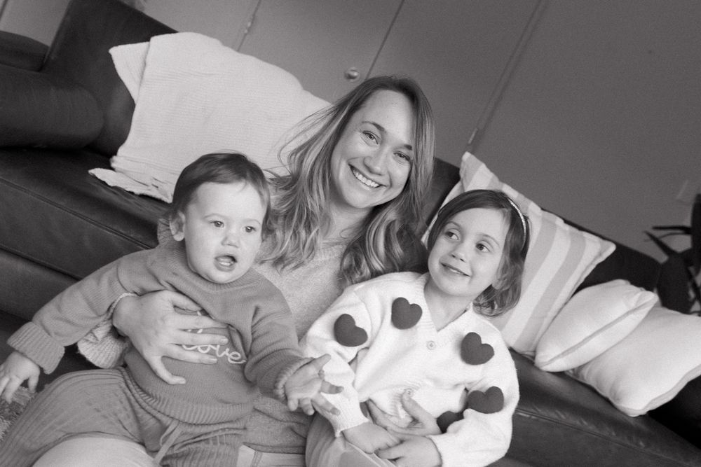 Black and white photo sequence capturing tender family moments on a couch.