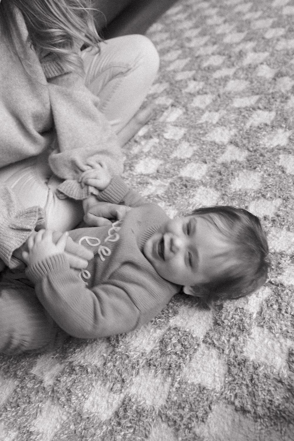 Black and white sequence of joyful interactions on a textured floor.