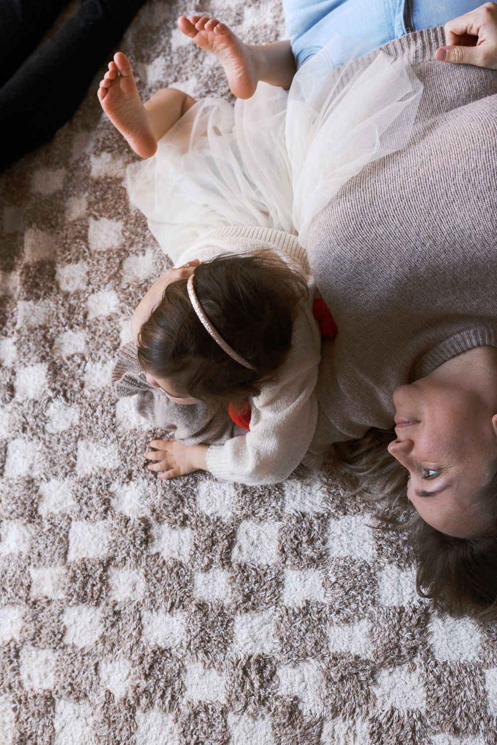 Candid overhead view of people relaxing on patterned carpet.