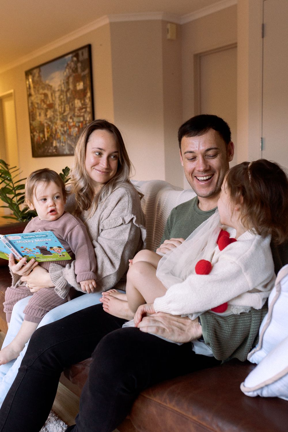 A series of candid moments showing a family relaxing together on a couch while reading and cuddling.